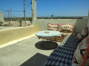 a patio with a couch and a table on a balcony at kaouki beachside apertmment - 4 peoples in Essaouira
