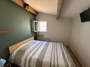 una camera da letto con un letto in una stanza con una finestra di Villa cosy à 200 m de la mer a Cap d'Agde Altre 7 foto