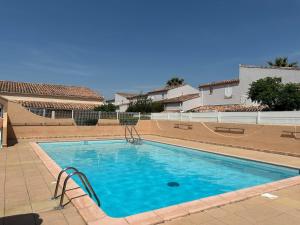 una grande piscina con acqua azzurra di Villa cosy à 200 m de la mer a Cap d'Agde