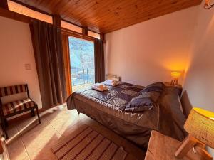 圣马丁德洛斯Duplex en el centro del pueblo con balcón terraza Ñire13的一间卧室，里面有一张床和一扇大窗户。