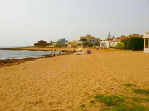 a sandy beach with houses and the ocean at Casa Lucia in Calabernardo