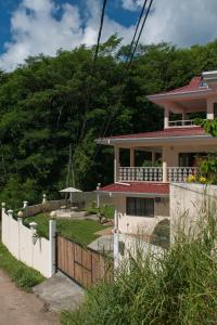 a house with a fence in front of it at Charlotte Villa in Takamaka