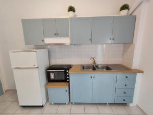 a kitchen with a white refrigerator and a sink at Elysian Light Apartment & Rooms in Syvota