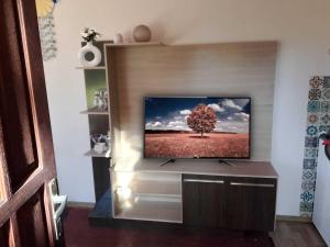 a flat screen tv in a living room with a tree at Sol naciente in Jaureguiberry