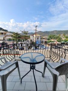 a table and chairs sitting on a patio at Elysian Light Apartment & Rooms in Sivota