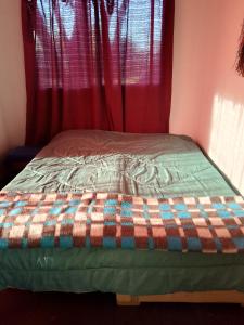 a bed in a room with red curtains at Sol naciente in Jaureguiberry