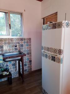 a kitchen with a refrigerator and a table next to a window at Sol naciente in Jaureguiberry