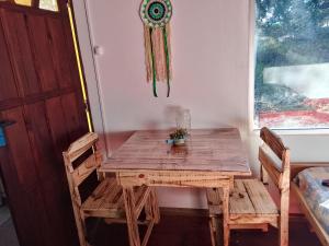 a wooden table and chairs in a room with a window at Sol naciente in Jaureguiberry