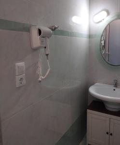 a bathroom with a sink and a phone on the wall at Twins home in Ierapetra