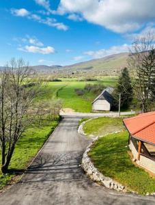 an empty road in a field with a barn at Wolf House in Korenica