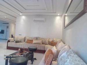 a living room with a couch and a table at Agréable maison in Agadir