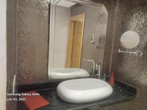 a bathroom with a white toilet and a mirror at Agréable maison in Agadir