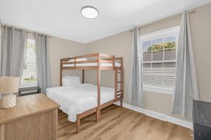a bedroom with a bunk bed and two windows at 3BR Elam Retreat • Work & Rest in Sunset Hills