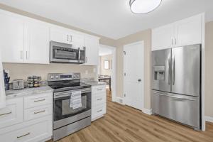a kitchen with white cabinets and stainless steel appliances at 3BR Elam Retreat • Work & Rest in Sunset Hills