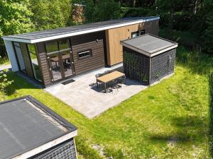 a small cabin with a bench in the grass at Luxury holiday home surrounded by water & forest in Sint Nicolaasga