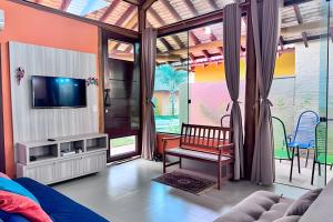 un soggiorno con TV e divano di Conforto e piscina no Centro de Bonito a Bonito