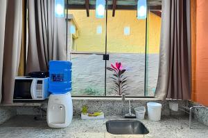 a kitchen counter with a sink and a window at Casa no Centro de Bonito no condomínio Eco Bonito in Bonito +30 photos
