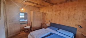 a bedroom with a blue bed in a wooden wall at La Dimora del Sole in Carano