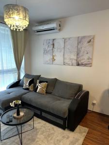 a living room with a couch and a table at Modern 2-bedroom apartment with balcony in Malacky