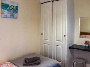 a bedroom with a bed and a mirror and a door at Arenig - Uk48508 in Bala +2 photos