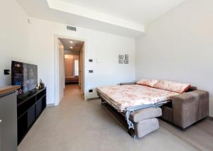a bedroom with a bed and a flat screen tv at Appartamenti Ciliegio & Ulivo in Dongo