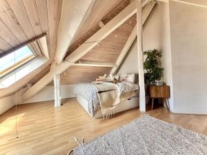 - une chambre mansardée avec un lit et une grande fenêtre dans l'établissement Cosy loft by the ocean, à La Celle-sous-Gouzon