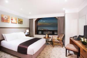 um quarto de hotel com uma cama grande e uma janela em Staz Hotel Jeju Robero em Jeju