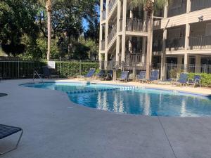 a swimming pool in front of a apartment building at Stunning Oceanview Luxury Remodel, Bikes Included! in Hilton Head Island