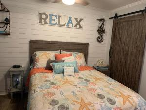 a bedroom with a bed with a relax sign on the wall at Stunning Oceanview Luxury Remodel, Bikes Included! in Hilton Head Island