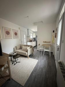 a living room with a couch and a table at A l'ombre du Marronnier in Préfailles
