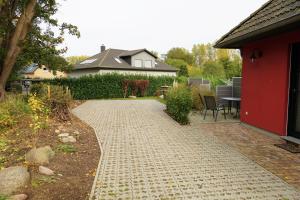 a garden with a brick walkway next to a house at Ferienhaus Am Pappelwald in Glowe