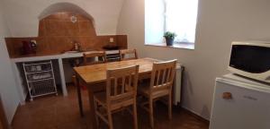 a kitchen with a wooden table and chairs in a kitchen at Zemědělská Usedlost Albrechtice in Sušice