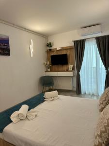 a bedroom with a large white bed and a television at Apartamente Victory Luxury Eforie Nord in Eforie Nord +27 photos