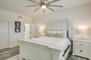 a bedroom with a white bed with a ceiling fan at Walk to Mississippi River Grafton Townhome! in Elsah