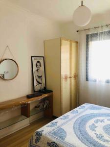 1 dormitorio con cama, espejo y tocador en Va Lungomare, en Vlorë