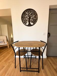 a table with two chairs and a tree on the wall at Casa Miká in Parede