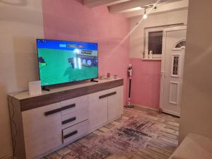 a living room with a flat screen tv on a dresser at Vikendica Artos in Bihać