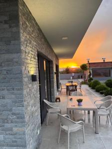 a patio with tables and chairs and a brick wall at Papa Apartments in Berovo