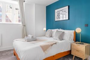 a bedroom with a large bed with a blue wall at Luxury Apartment in Nottinghams Best Location in Nottingham