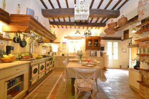 ピエガーロにあるLuxury Villa Retreat in Città della Pieve, Umbriaのテーブルとコンロとテーブルのある広いキッチン sidx sidx