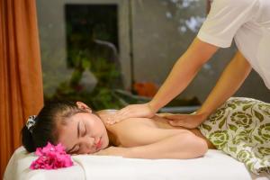 a woman getting a massage on a bed at Adaaran Club Rannalhi - All Inclusive - 45 Minutes away from Male by Speedboat in South Male Atoll