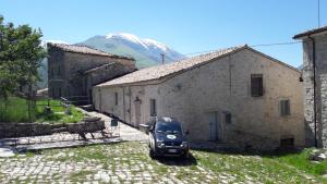 a car parked in front of a building with a mountain at Poesia d'Abruzzo CR 06804dueAFFzerozerozerodue in Caramanico Terme