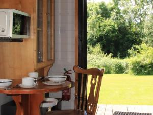 a table with cups and saucers on it next to a window at Red Lodge - Uk10988 in Llandogo