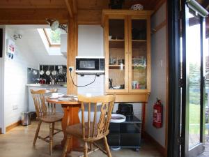 a kitchen with a table and chairs in a room at Red Lodge - Uk10988 in Llandogo +5 photos