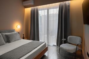 a bedroom with a bed and a window and a chair at Tproject in Preveza