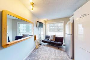 a living room with a mirror and a chair at Whitefoot Lodge 314 in Big White