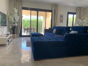 a living room with blue couches and a table at Blanca, Marassiمراسي العلمين in El Alamein