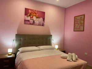 a bedroom with a bed with pink walls and two lamps at Giulieda in Magicland in Naples