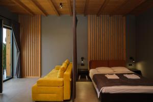 Un dormitorio con una cama y una silla amarilla. en Chalet Panorama (Апартаменти), en Bukovel