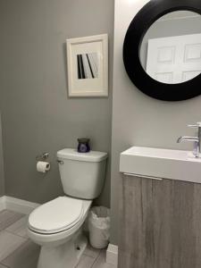 a bathroom with a white toilet and a sink at Family-Friendly 4BR Retreat Fully Furnished in Sarnia